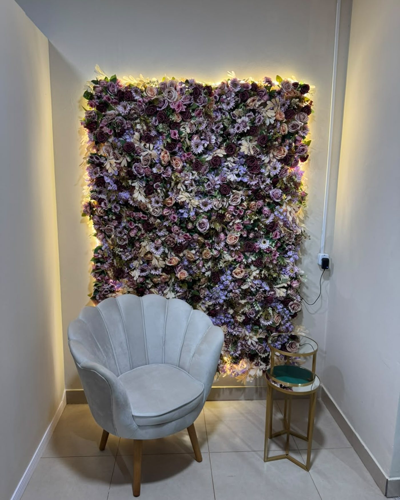 Parede de flores com poltrona de veludo.