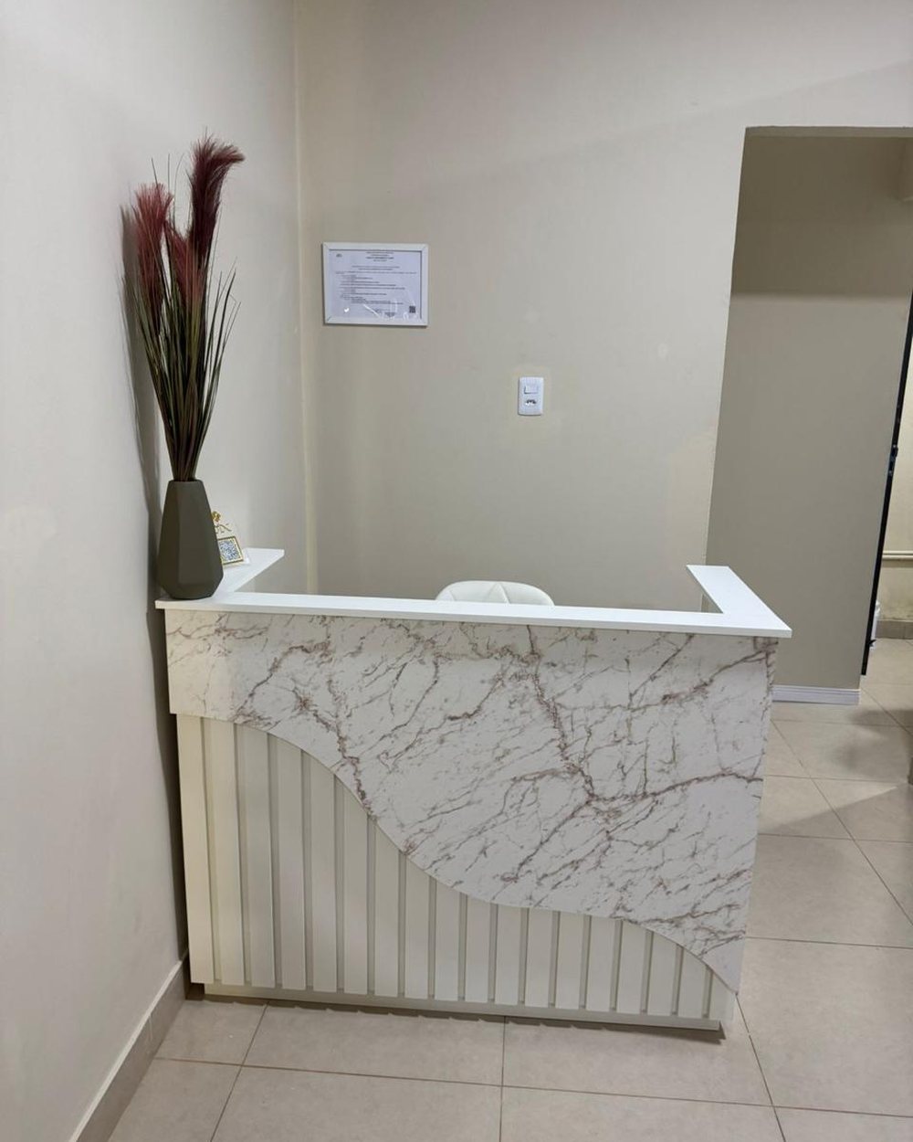 Recepção com balcão de mármore.