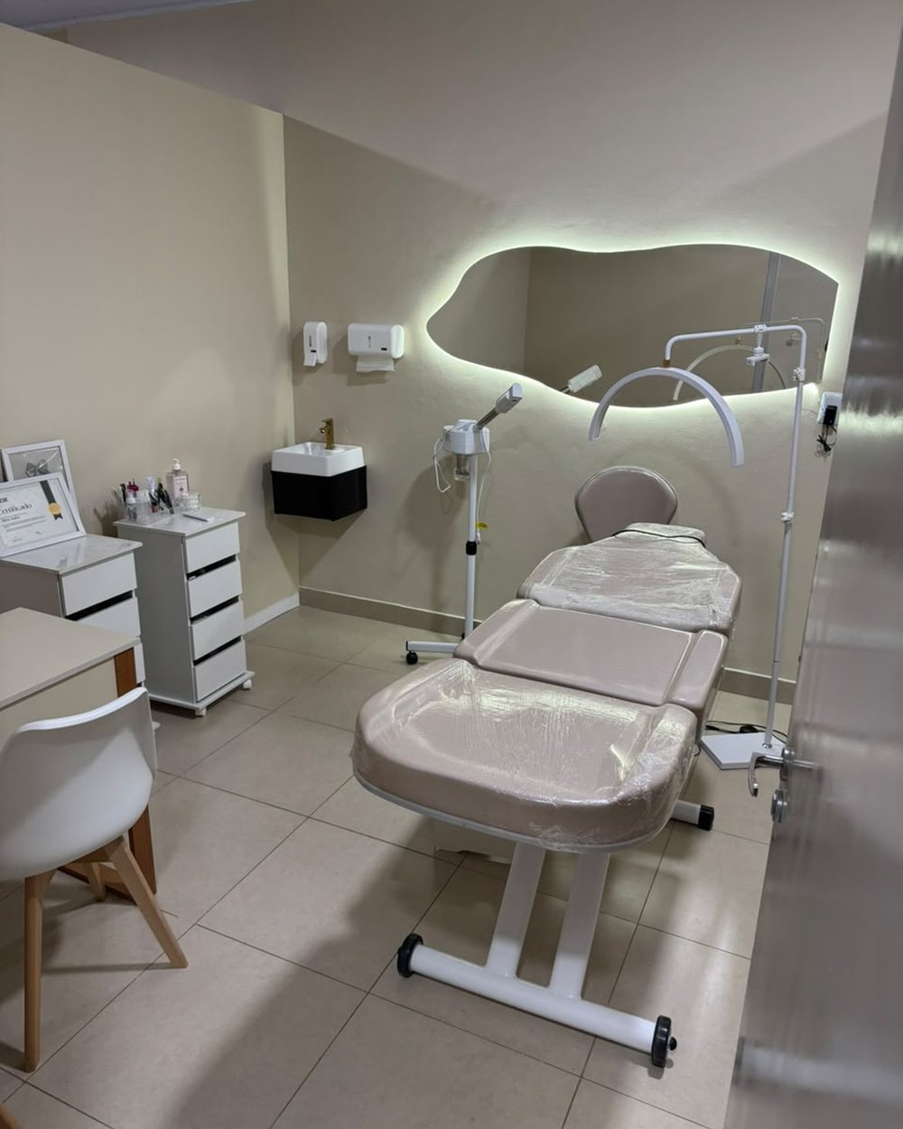Sala de estética facial com maca e equipamentos.